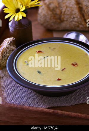 warm image of curry soup, place on a wooden tray, showing bread in the background. room for text and copy space Stock Photo