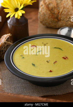 spicy cream soup place on a wooden tray, showing bread in the background. room for text and copy space Stock Photo