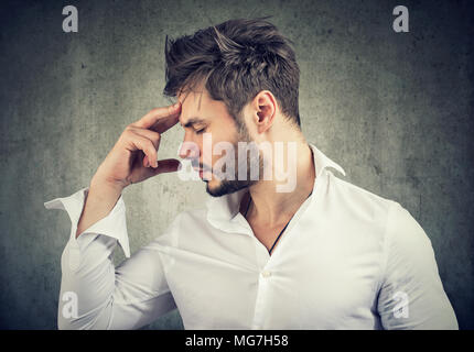 Formal man touching forehead thinking deeply and looking for solution. Stock Photo