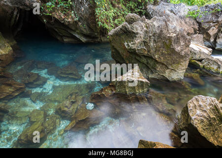 Transparent and blue water at a rocky lagoon next to the Tham Chang (or Jang or Jung) Cave in Vang Vieng, Laos. Stock Photo