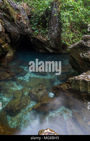 Transparent and blue water at a rocky lagoon next to the Tham Chang (or Jang or Jung) Cave in Vang Vieng, Laos. Stock Photo