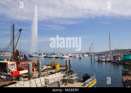 Panoramic view of historic Geneva skyline with famous Jet od'Eau fountain and ships at harbor district in beautiful evening light at sunset with blue sky and cluds in summer, Geneva, Switzerland. Stock Photo