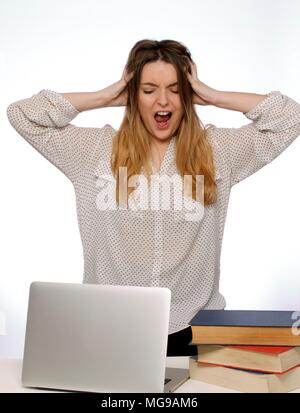 Young woman with hands in hair and laptop. Stock Photo