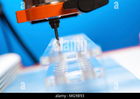 CNC milling machine drilling plastic block#. Stock Photo