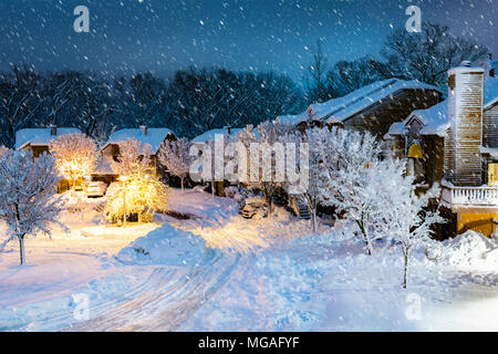 Night snowfall in a New Jersey village with wooden houses. Stock Photo