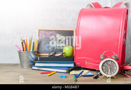 back to school text on black chalk board with bag and school supplies on wood background, Back to school and education concept Stock Photo