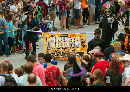 Two people in costumes carry the Little Five Points Halloween Parade banner, marking the beginning of the parade on October 15, 2016 in Atlanta, GA. Stock Photo
