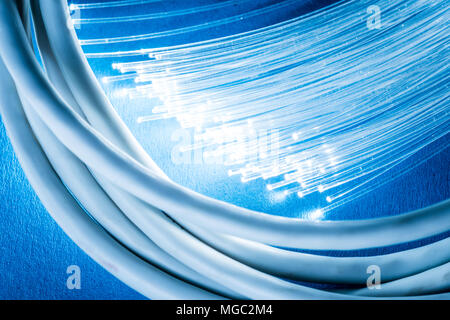 Network cables and optical fibers with lights in the ends at the background. Stock Photo