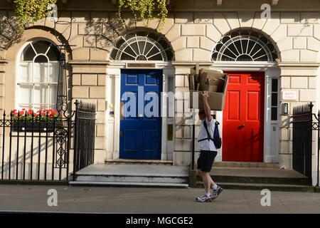 Man walking along London street, carrying box of cardboard on head, London, England, UK Stock Photo