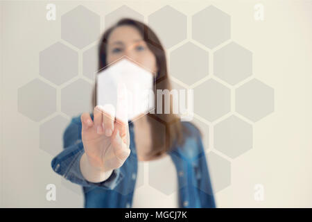 Woman touching an hexagonal button on a digital interface. Technology and choices concept Stock Photo
