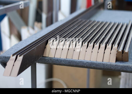 Furniture accessories. Colorful wooden floor for home renovation. Manufacture of skirting boards in a furniture factory. Stock Photo