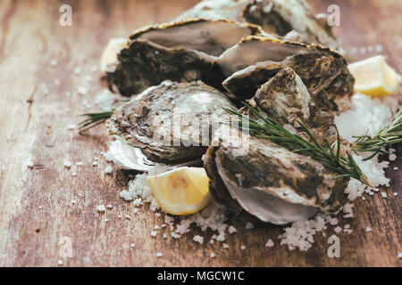 Open shell oyster with lemon and salt on a wooden board Stock Photo