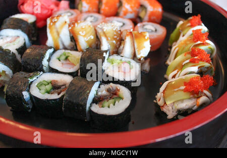 Japanese rolls, arranged on a black tray with a red border Stock Photo