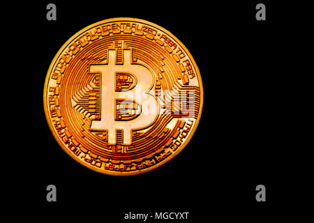 Bitcoin in the dark. Close up view on heap of golden bitcoins. Black background with copyspace Stock Photo