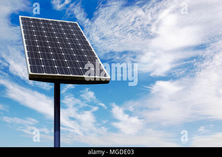 Small Solar Panel Against a Cloudy Blue Sky Stock Photo