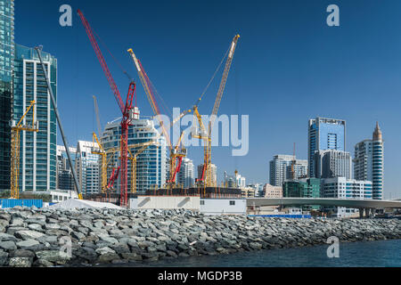 Building construction cranes in the marina of Dubai, UAE, Middle East. Stock Photo