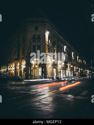 One of the main streets in the center of Turin with the illuminated arcades shooting at night while the red headlights of the cars whizzing Stock Photo