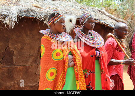 Masai women wearing colorful green and red dresses during a tribal rite in an African village in Kenya, near Nairobi Stock Photo