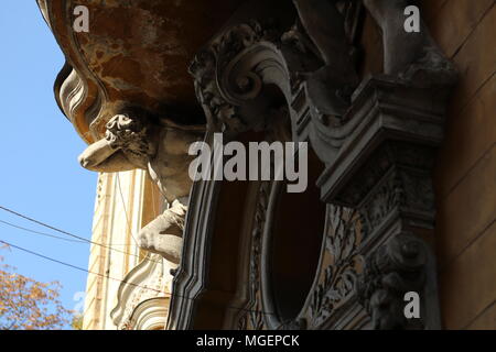 Capital with a statue illuminated by the sun while the rest of the balcony remains in the shadows in a building in the historic center of Bucharest Stock Photo