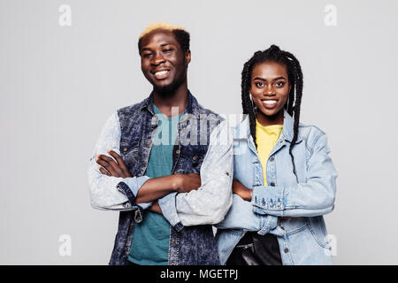 Portrait of a confident young african couple dressed in summer clothes standing with arms folded isolated over white Stock Photo