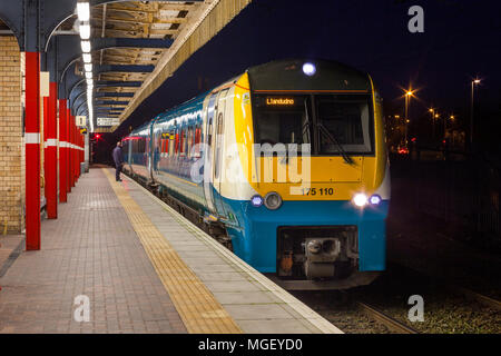 An  Arriva trains Wales class 175 diesel train calling at  Warrington Bank Quay railway station at night