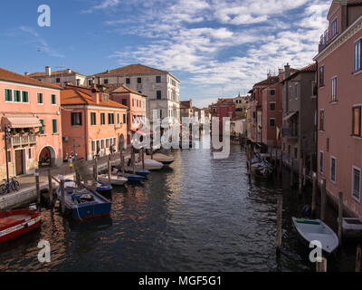 Panoramic view on Chioggia canal surrounded by boats and houses in Veneto region of northern Italy Stock Photo