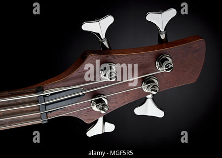 close-up studio shot of a maroon bass guitar head stock on black background Stock Photo
