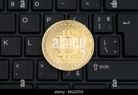 Abstract golden bitcoin on a black computer keyboard Stock Photo