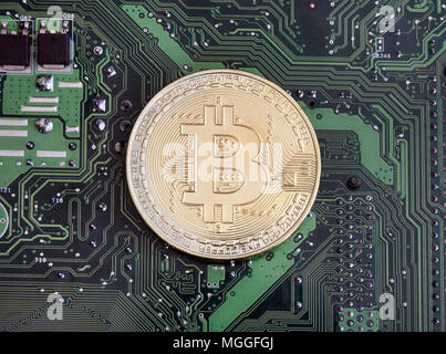 Abstract golden bitcoin on printed circuit board Stock Photo