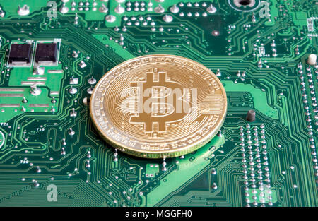 Abstract golden bitcoin on printed circuit board Stock Photo