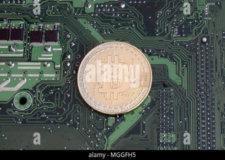 Abstract golden bitcoin on printed circuit board Stock Photo