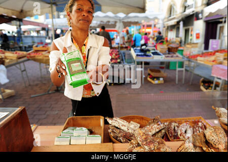 A vendor shows a bag of Le Puy green lentils at the local fruit and veg market in the city of Le-Puy-en-Velay, France Stock Photo