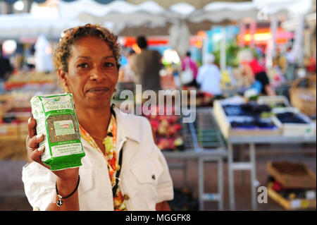 A vendor shows a bag of Le Puy green lentils at the local fruit and veg market in the city of Le-Puy-en-Velay, France Stock Photo