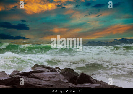 Amazing beach sunset with endless horizon and lonely figures in the distance, and incredible foamy waves. Stock Photo