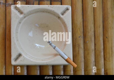 cigarette on tile ash tray Stock Photo