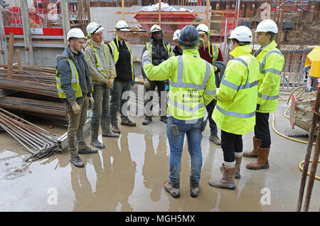 A 'Toolbox Talk' takes place on a London building site. Site staff receive training and project information from the senior project management team Stock Photo
