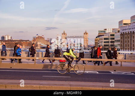 City of London, London, UK - February 8, 2018. Commuters make their way home during rush hour across London Bridge, either walking, cycling, or runnin Stock Photo