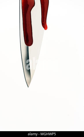 Single sharp silver knife edge in macro closeup with red blood droplets dripping off the blades edge with white background and copyspace area for murd