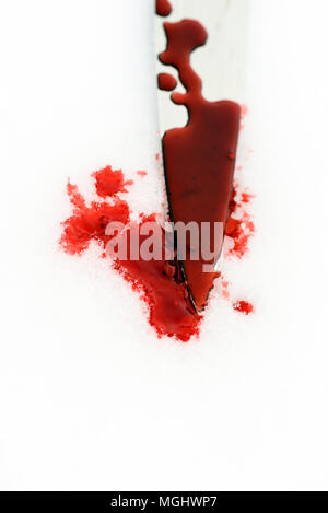 Sharp metal kitchen knife edge used as a violent murder weapon with blood drops on a white snow background. Blade covered in violence with copy space 