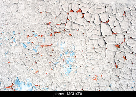 Old flaking blue paint with an orange vibrant undercoat showing up through cracked broken plaster with a copyspace area for DIY reconstruction and bui Stock Photo