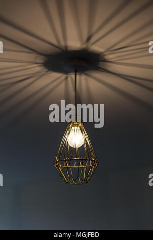 Brass, industrial lighting casting shadows on the ceiling Stock Photo