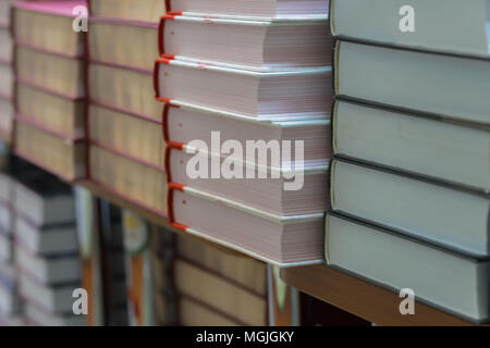 Many books, textbooks or fiction in rows lying on the shelves in library or in the modern urban bookshop. Self-study, educational, manuals, textbooks, Stock Photo