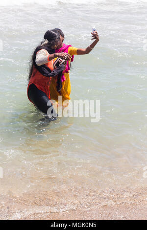 MASI MAGAM FESTIVAL, PUDUCHERY, PONDICHERY, TAMIL NADU, INDIA - March 1, 2018. Unidentified Indian pilgrims women with colored Sari bathing taking sel Stock Photo