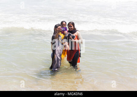 MASI MAGAM FESTIVAL, PUDUCHERY, PONDICHERY, TAMIL NADU, INDIA - March 1, 2018. Unidentified Indian pilgrims women with colored Sari bathing taking sel Stock Photo