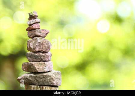 Stacked stone pyramid in front of blurry background with bokeh Stock Photo