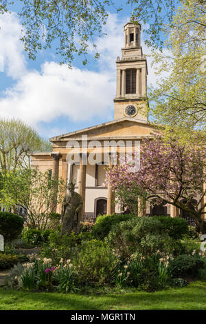 the trinity church in central london on a bright and sunny spring season day with blue skies and clouds. gardens at trinity church yard in city centre Stock Photo