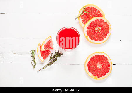 Grapefruit juice and ripe grapefruits on a wooden background. Stock Photo