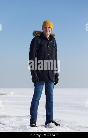 Man in winter clothes on the ice of Gulf of Finland Stock Photo