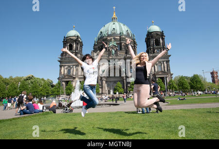 Berlin, Germany. 29th Apr, 2018. 29 April 2018, Germany, Berlin: Nadja (27) and Natalie (36, R) from Ukraine jumping for a photo before the Berlin Cathedral. Credit: Paul Zinken/dpa/Alamy Live News Stock Photo