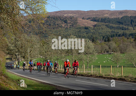 Fort Augustus, Scotland, UK. 29th April, 2018. Cyclists taking part in the Etape Loch Ness closed road cycle sportive following a 360-degree 66-mile / 106-Km route around Loch Ness, Scotland, starting and finishing in Inverness. This event is expected to attract 5,600 cyclists from across Scotland and the UK. Thousands of pounds will be raised by participants for Macmillan Cancer Support, the official event charity. This image shows participants reaching the half way point near Fort Augustus. Cliff Green/Alamy Live News Stock Photo